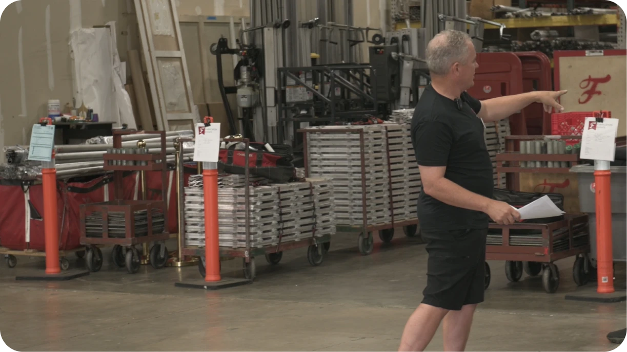 Event rental staging area with traffic cones holding job packets and organized inventory ready for loading 